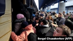Люди пытаются сесть на эвакуационный поезд на центральном вокзале Киева 4 марта 2022 года.