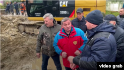 Губернатор Андрей Бочаров (в центре в куртке с гербом) и другие представители администрации на месте аварии в Волгограде. Скриншот видео V1.RU