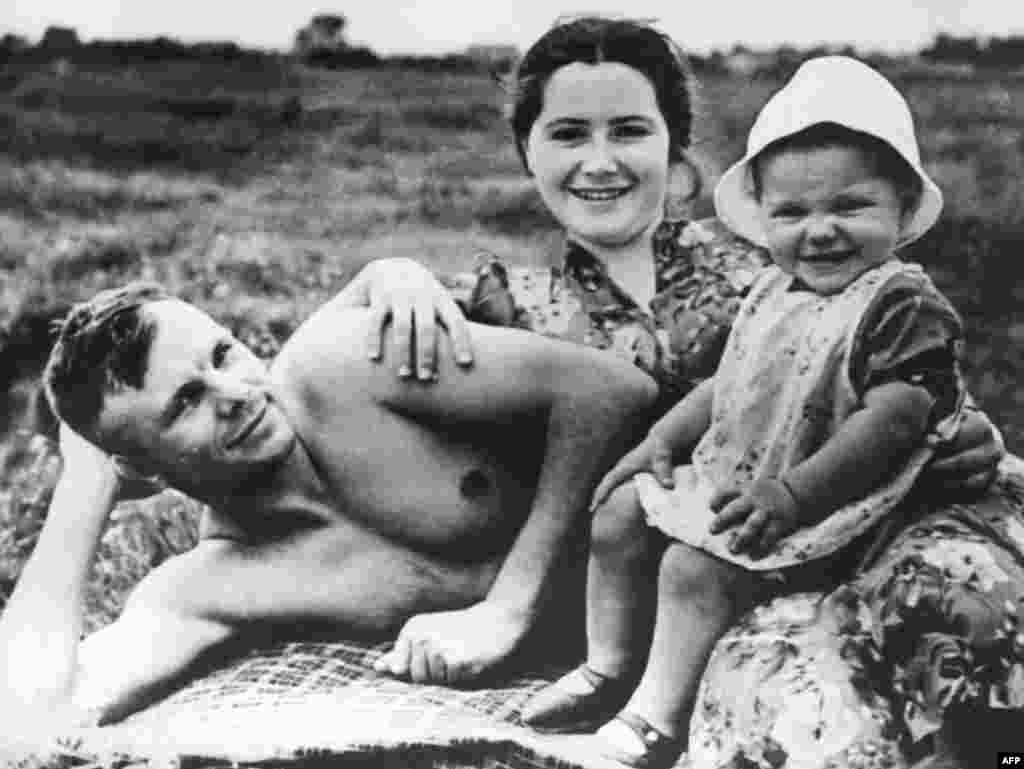 Советский космонавт Юрий Гагарин на пляже с женой Валентиной и дочерью Еленой в июне 1960 года, менее чем за год до того, как он вошел в историю как первый человек, совершивший полет в космос