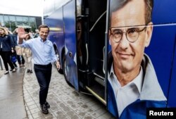 Ульф Кристерссон, лидер Умеренной партии, во время предвыборной кампании возле автобуса со своим портретом в Уппсале, Швеция. 7 сентября 2022 года. Фото: Reuters