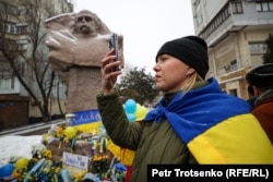 Люди у памятника украинскому поэту Тарасу Шевченко в знак поддержки Украины в день второй годовщины войны. Алматы, фото 24 февраля 2024 года