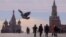 CHINA-RUSSIA/DIPLOMACY -- People, including Russian law enforcement officers, walk near St. Basil's Cathedral and the Kremlin's Spasskaya Tower, as a pigeon flies over Red Square in central Moscow, Russia, March 20, 2023