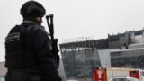 Сотрудник МВД напротив сгоревшего здания "Крокус Сити Холл" 23 марта 2024