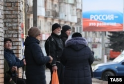 Жители оккупированного Россией Мелитополя на автобусной остановке, 13 февраля 2023 года, фото ТАСС