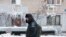 Russia -- A man walks past an apartment block, that is left without heating and hot water due to a boiler house failure
