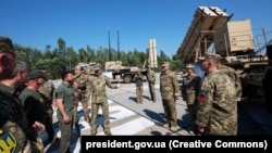 Президент Украины Владимир Зеленский (справа) в День Вооруженных сил ВСУ во время осмотра современных образцов вооружения и военной техники, которые состоят на вооружении украинских защитников неба, 6 августа 2023 года. Слева на фото американский ЗРК Patriot