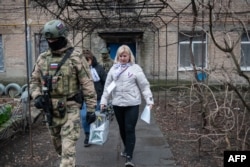 Участники избирательной комиссии проводят голосование в оккупированном Донецке, 14 марта 2024 года