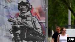 На фотографии, сделанной 27 мая 2023 года в российском городе Белгороде, примерно в 40 км от границы с Украиной, запечатлен рекламный щит, рекламирующий военную службу по контракту