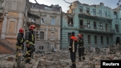 Cпасатели возле разрушенных в результате российской ракетной атаки жилых домов в Одессе. 23 июля 2023 года. Фото: Reuters