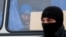 Migrant worker looks out of a police vehicle during a raid carried out by Kaliningrad Federal Migration Service officers looking for immigrants who violate the law