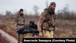 Украинские военные несут Васю после полученной травмы