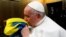 VATICAN – A handout picture provided by Vatican Media Press Office, shows Pope Francis (C) kisses the Ukranian national flag during the screening of the film 'Freedom On Fire: Ukraine's Fight for Freedom', at the Vatican City, 24 February 2023