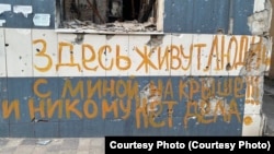 Надпись на одном из разрушенных домов в Мариуполе, март 2023 года