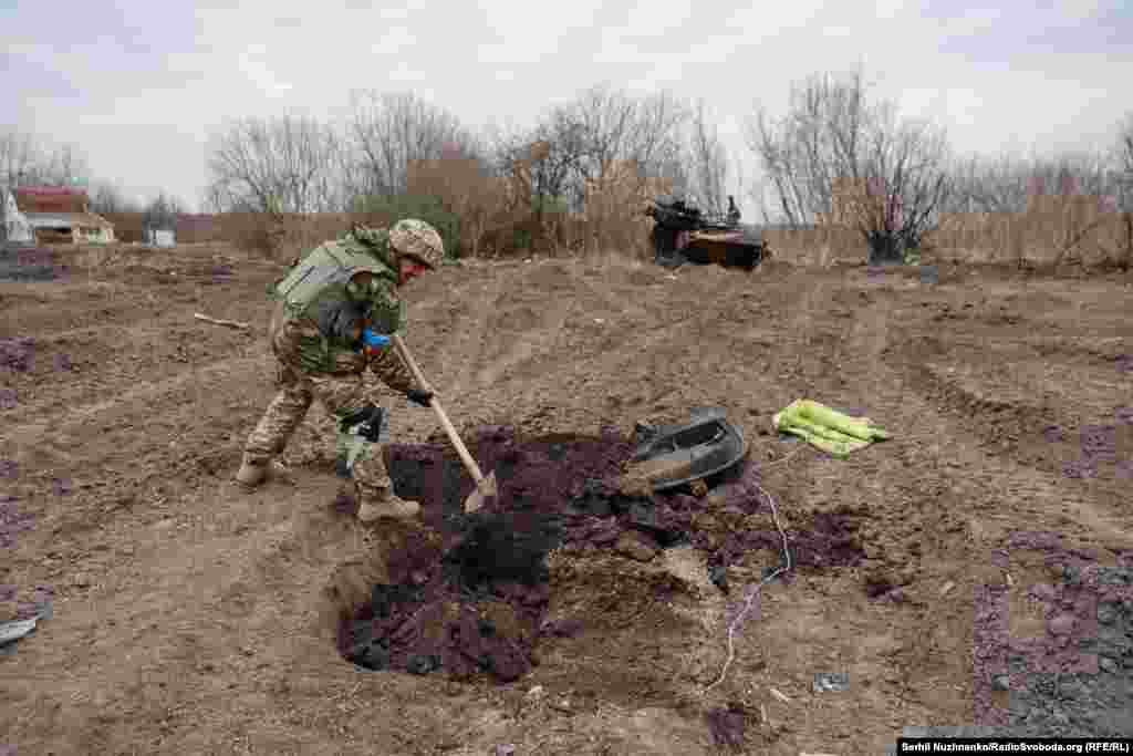 Украинский военный закапывает останки российского солдата, чтобы его не растащили собаки, в недавно освобожденном селе Лукьяновка Киевской области, март 2022 года / Фотография справа: март 2024 года