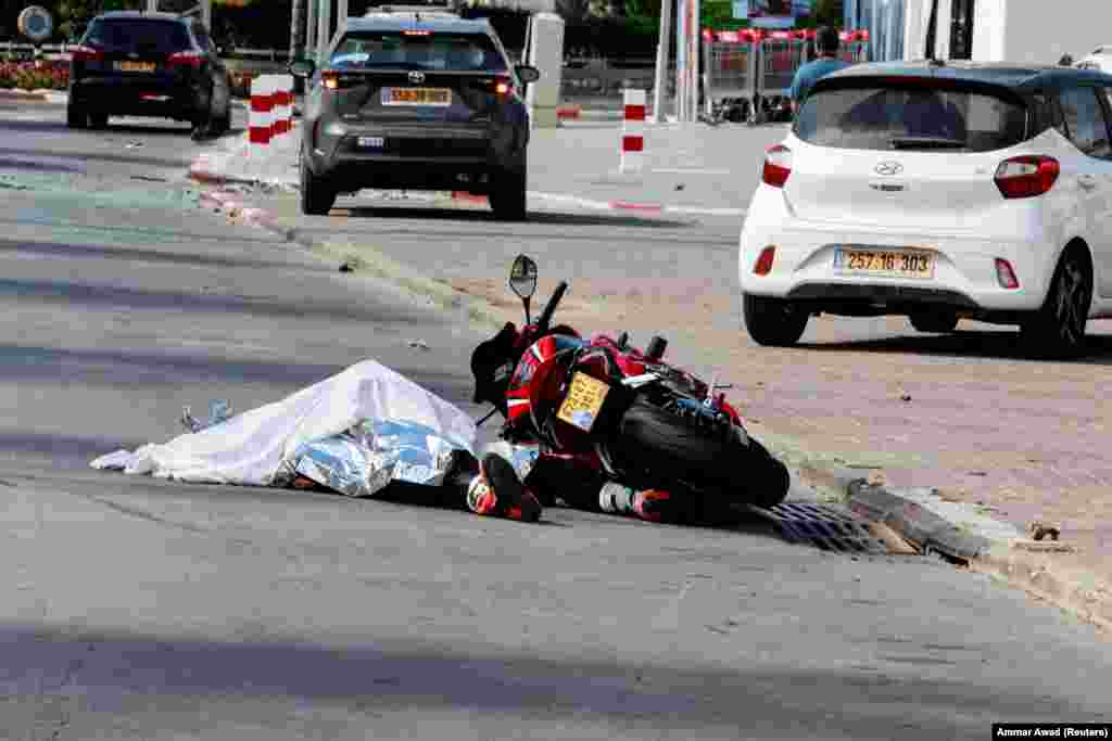 Тело автомобилиста лежит на дороге после массового проникновения боевиков ХАМАС из сектора Газа, в Сдерот на юге Израиля, 7 октября 2023 года