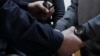 RUSSIA -- A police officer puts the handcuffs on Russian former economy minister Alexei Ulyukayev 