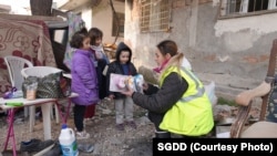 Волонтерка дарит игрушки детям, выжившим во время землетрясения. Хатай, 11 февраля. Фото: SGDD