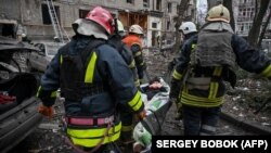Спасатели эвакуируют раненого жителя дома, разрушенного в результате российской ракетной атаки по Киеву 29 декабря