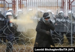 Польский военнослужащий распыляет слезоточивый газ во время столкновений между мигрантами и польскими пограничниками на белорусско-польской границе недалеко от Гродно, Беларусь, 16 ноября 2021 года, фото AP