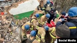 Спасатели извлекают пострадавшего из-под завалов дома в одном из населенных пунктов Сумской области, подвергшегося бомбардировке армии РФ