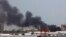 Heavy smoke bellows above buildings in the vicinity of the Khartoum's airport on April 15