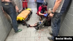 Медики оказывают первую помощь одному из пострадавших сотрудников коммунального предприятия в Херсоне, попавшему под обстрел российских войск