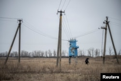 Саперы обследуют территорию под линиями электропередачи на предмет мин и неразорвавшихся снарядов, Харьковская область, 21 марта 2023 года. Фото: Reuters