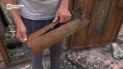 Житель села Циркуны показывает российский снаряд, который прилетел в его дом и уничтожил его