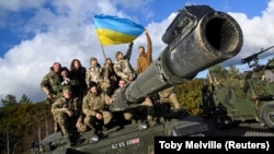 Украинские военные позируют на танке Challenger 2 на военной базе Bovington Camp в Великобритании