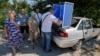 Мобильный пункт голосования на багажнике автомобиля в оккупированном Россией Мариуполе. 31 августа 2023 года. Фото: Reuters
