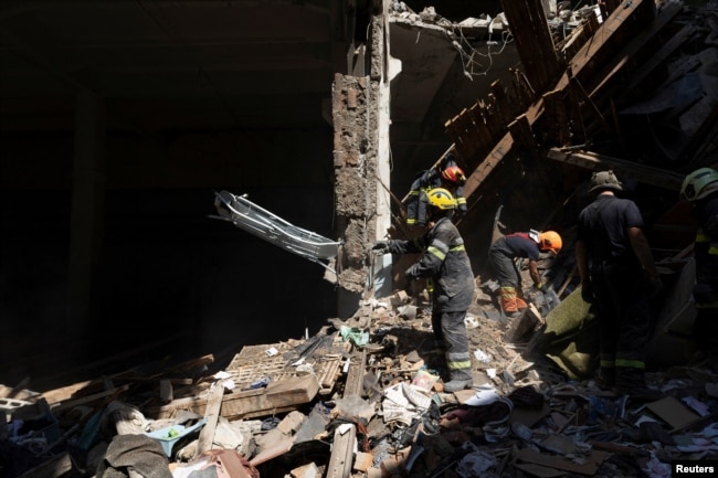 Спасатели разбирают завалы жилого дома в Харькове, где в результате обстрелов погибли 19 человек и десятки получили ранения. 18 августа 2022 года. Фото: Reuters