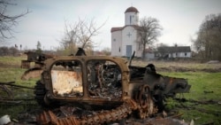 Сгоревшая российская военная машина на фоне православной церкви в селе Липовка недалеко от Киева, 11 апреля 2022 года
