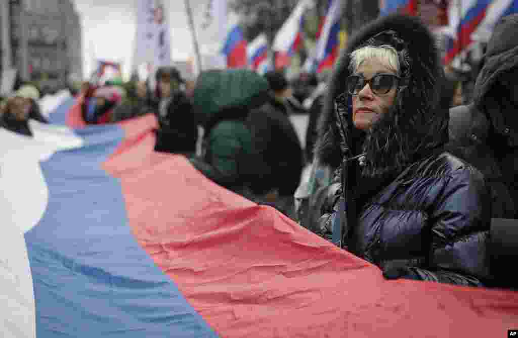 Люди с российским флагом на Марше Немцова в Москве
