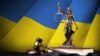GENERIC – Ukraine flag with statue of of justice Themis, constitution and judge hammer on black drapery. Concept of judgement and punishment