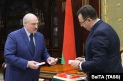 Health Minister Dzmitry Pinevich presents a batch of Russia's Sputnik V vaccine to Alyaksandr Lukashenka in Minsk on March 26, 2021.