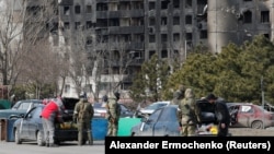 Военнослужащие пророссийских войск проверяют автомобили мирных жителей в Мариуполе, Украина, 20 марта 2022 года 