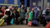 Люди, спасающиеся от российского вторжения в Украину, выходят из поезда из Краматорска на вокзале во Львове. Украина, 22 марта 2022 года