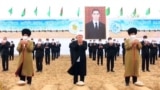 Туркменские старейшины и чиновники на фоне изображения президента Сердара Бердымухамедова, который занял пост в марте 2022 года вместо отца. Портреты Сердара и Гурбангулы Бердымухамедовых висят повсюду, их нет "разве что в туалетах"