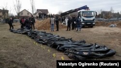 Тела мирных жителей, которые, по словам украинских официальных лиц, были убиты во время вторжения России, а затем эксгумированы из братской могилы в городе Буча под Киевом, Украина, 8 апреля 2022 года 