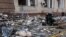 A firefighter rests amid debris as a mannequin lies on the ground. Kharkiv, Ukraine, April 16, 2022. REUTERS/Alkis Konstantinidis 
