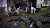 Тела убитых в Буче грузят в автомобиль, чтобы отвезти в морг. 12 апреля 2022 года 