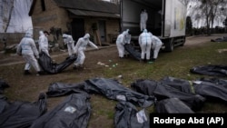 Тела убитых в Буче грузят в автомобиль, чтобы отвезти в морг. 12 апреля 2022 года 