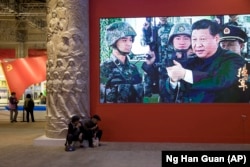 Си Цзиньпин в роли великого руководителя Народно-освободительной армии Китая на выставке в Пекине, приуроченной к XIX съезду КПК. 19 октября 2017 года