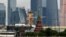 Russia -- Tourists take pictures on a bridge, with the Kremlin's towers and the buildings of the Moscow International Business Center (Moskva City) seen in the background, in central Moscow, June 6, 2017