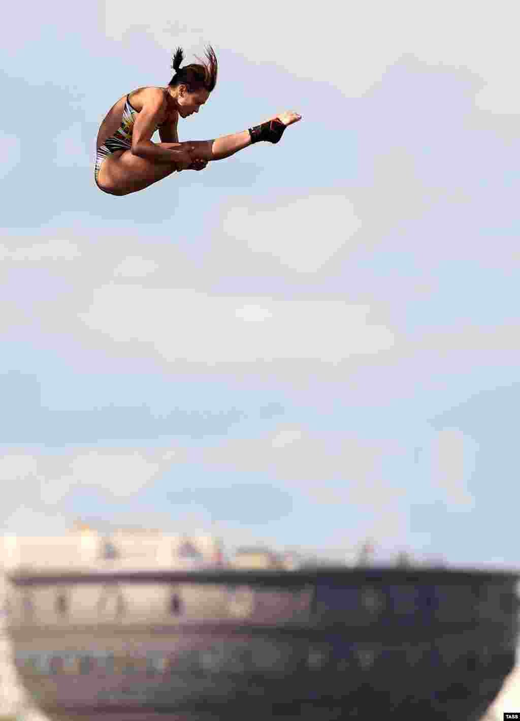 К сожалению, во время тренировки одна из участниц неудачно приземлилась на воду из-за чего не смогла выступить на самом чемпионате На фото - немецкая спортсменка Анна Бадер прыгает с 20 метров