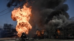 Велосипедист проезжает мимо пожара в Харькове 25 марта 2022 года