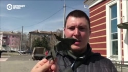 Житель Краматорска показывает осколок ракеты, которая попала по вокзалу в Краматорске 