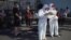 CHINA -- Medical staff members in full protective gear stand outside the Guangan sports centre to assist people who live near or who have visited the Xinfadi Market, a wholesale food market where a new COVID-19 coronavirus cluster has emerged, for testin