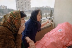 Two Azerbaijani women in Baku are overcome with grief during a funeral for a relative on January 28, 1990.