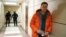 RUSSIA -- Russian opposition leader Aleksei Navalny stands near law enforcement agents in a hallway of a business centre, which houses the office of his Anti-Corruption Foundation (FBK), in Moscow, December 26, 2019